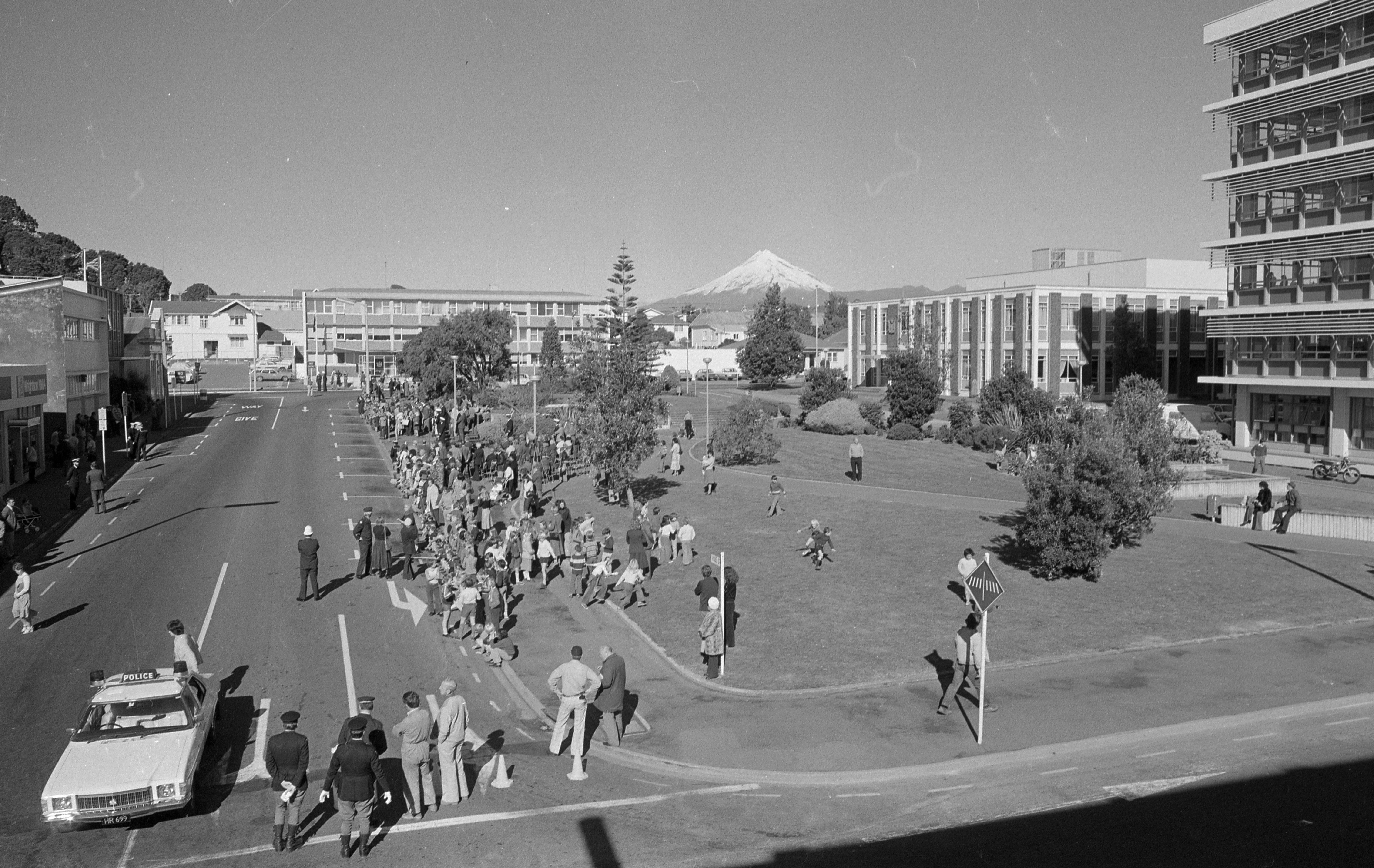 H.M.N.Z.S. Taranaki procession showing the site of the old post office and clock tower (1979). Caleb Wyatt. Collection of Puke Ariki (PHO2011-2190).