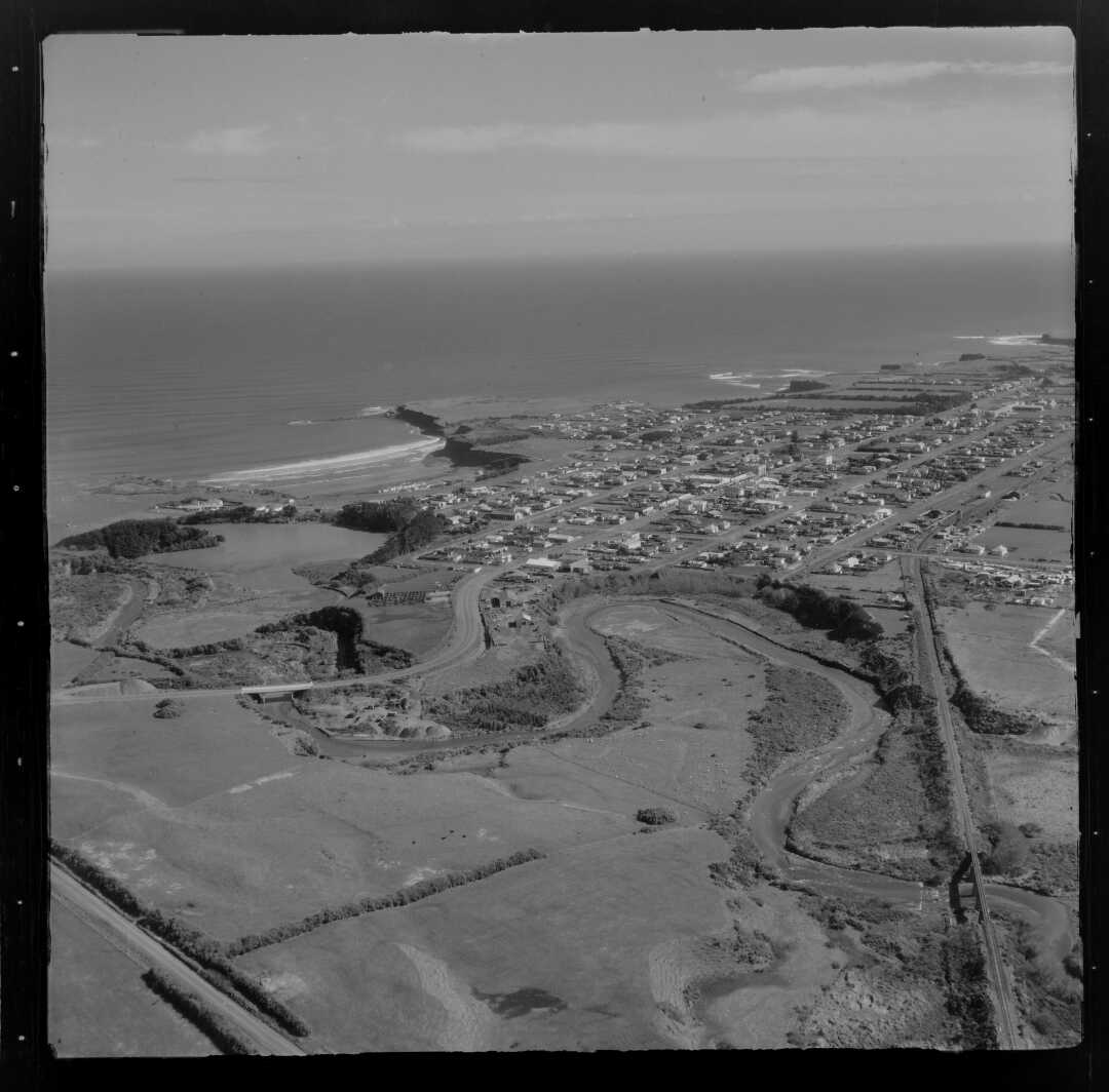 View of Opunake with the Waiaua River in the midground (22 August 1958). Whites Aviation. Collection of the Alexander Turnbull Library (WA-47148-F).