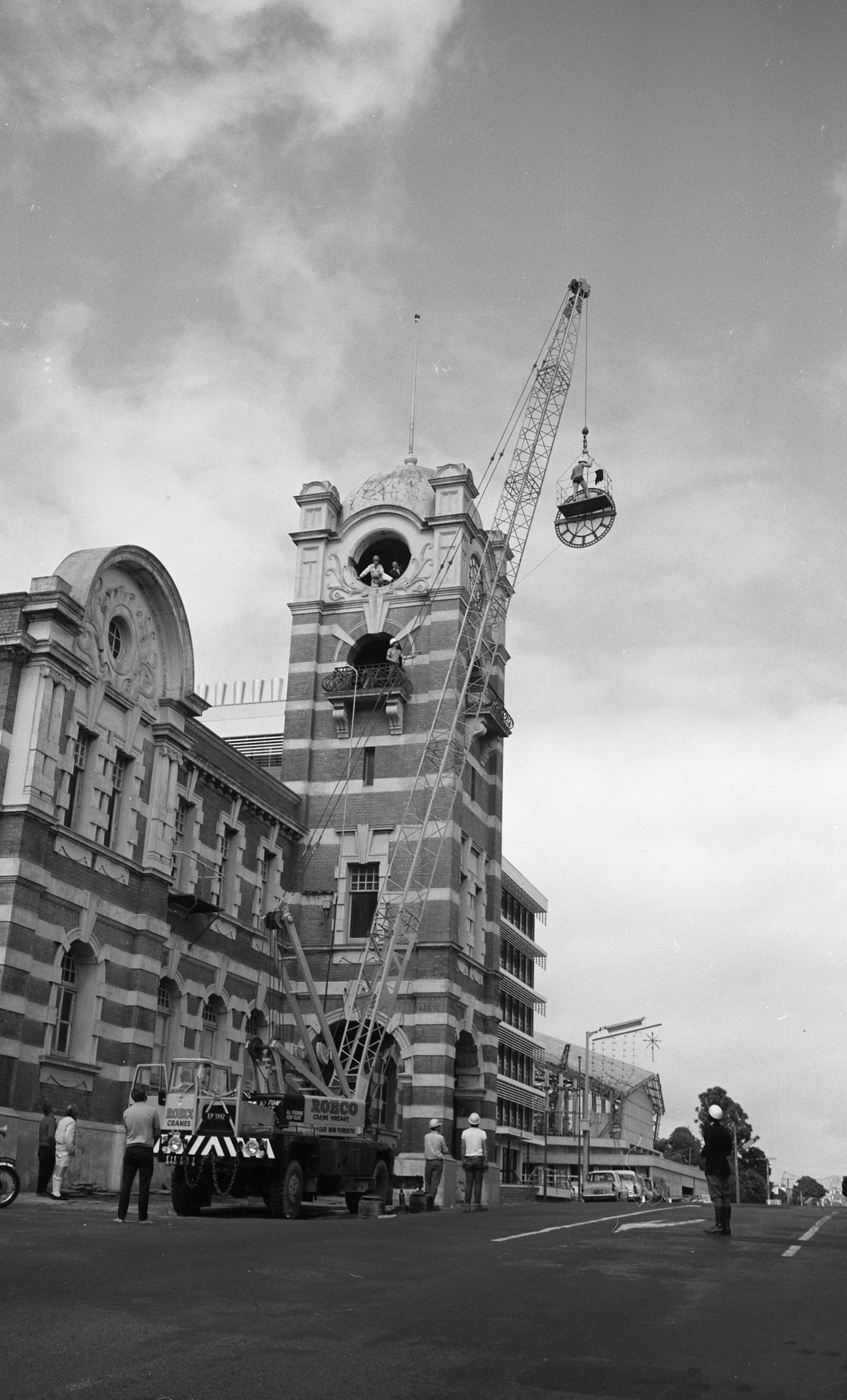 Removing the clock faces from the clock tower before demolition (1 February 1969). Caleb Wyatt. Collection of Puke Ariki, New Plymouth (PHO2011-2048).