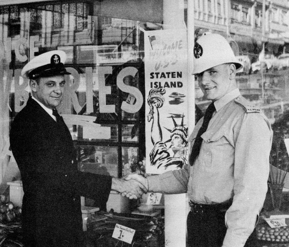 USS Staten Island Gunner’s Mate J.E. Dalrymple shaking hands with a local police officer (November 1958). Unknown photographer. Commemorative cruise book courtesy of Jim Freund.